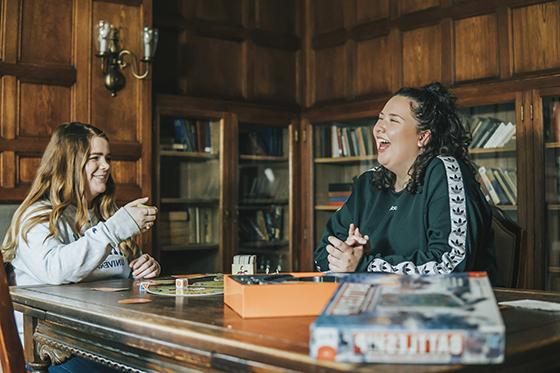 Photo of two Chatham University students hanging out in a historic mansion that's been converted to University housing